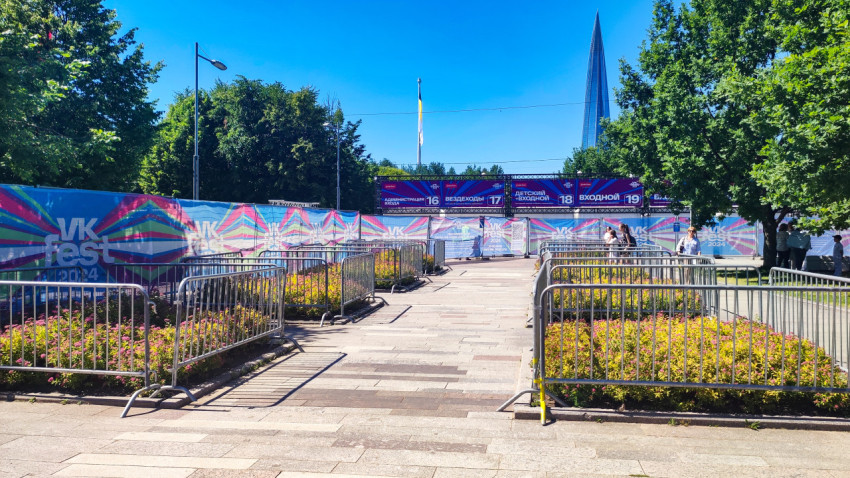 Входная зона VK Fest 2024 с указателями и временными ограждениями на аллее