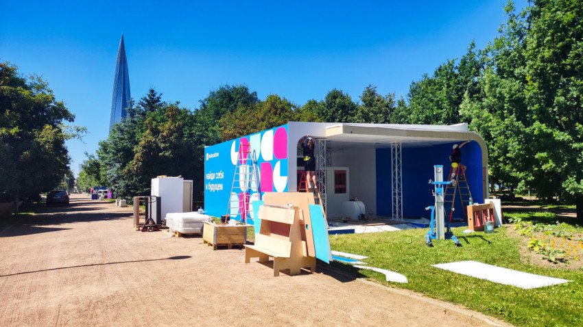 Монтаж промо-павильона Education с лестницами и строительными материалами на площадке