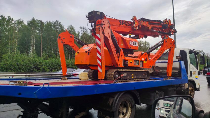 Гусеничный подъёмник ARLIFT на платформе грузовика на мокрой дороге