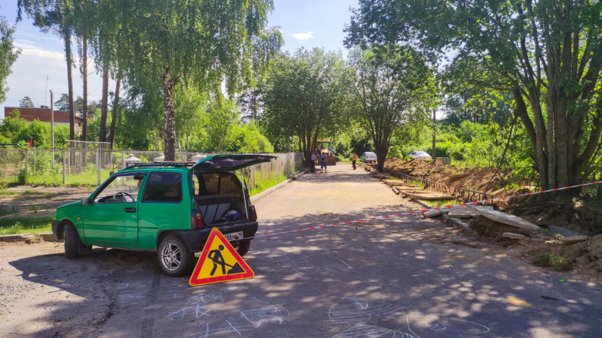 Знак «Дорожные работы» и сигнальная лента у раскопок во дворовом проезде