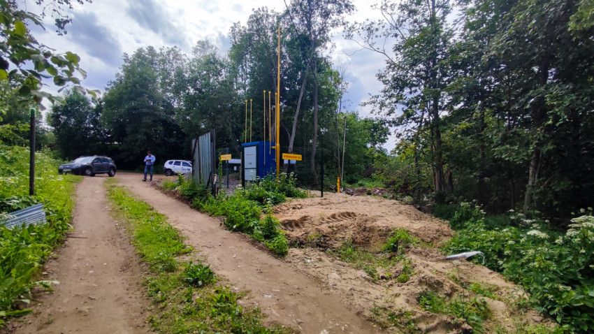 Подъезд к газовому объекту с раскопкой грунта и автомобилями на дороге