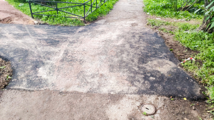 Асфальтовая заплата на пересечении дорожек рядом с крышкой люка