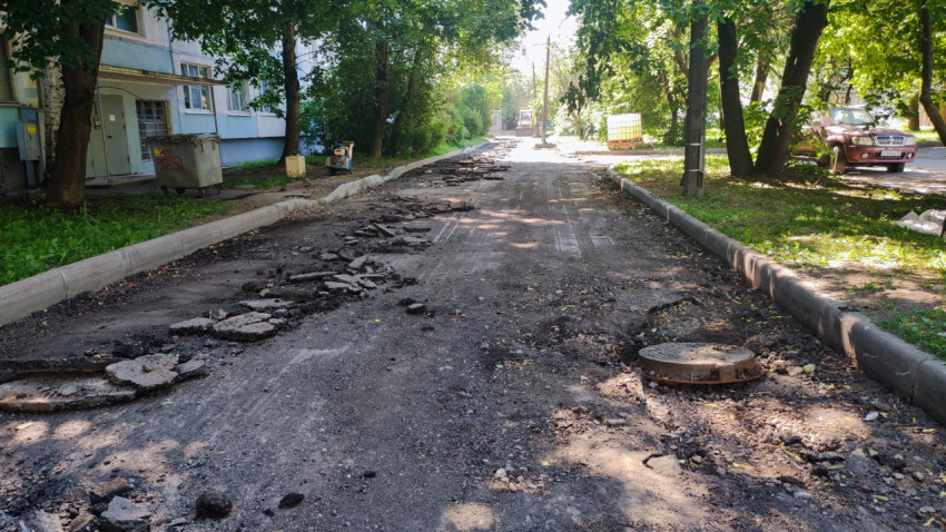 Разобранный асфальт и закрытый люк на дворовой дороге во время ремонта