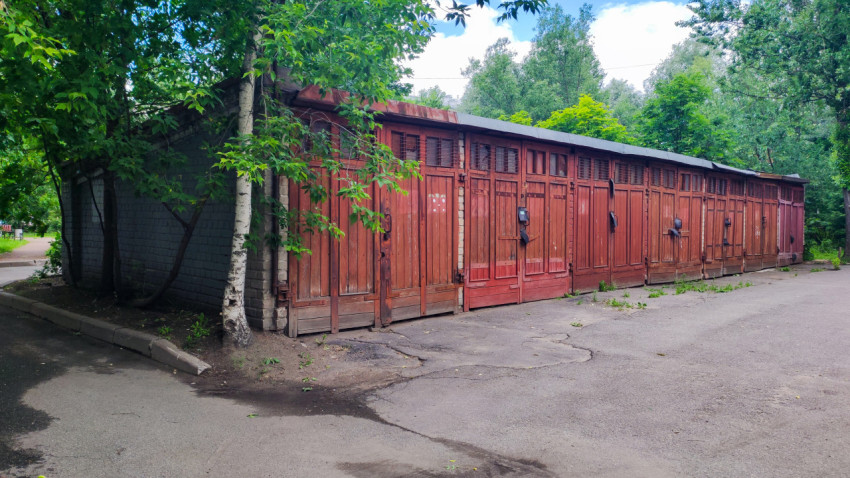 Ряд старых деревянных гаражных ворот вдоль дворового проезда