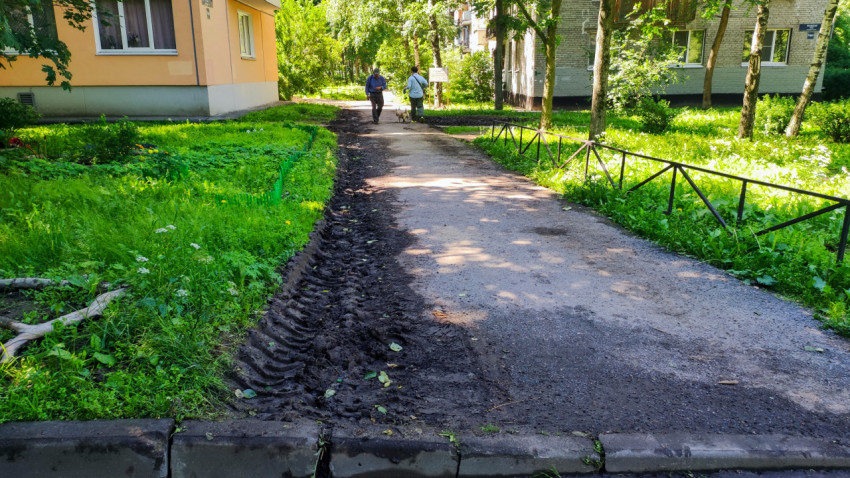 Дворовая дорожка между жилыми домами с следами техники после земляных работ