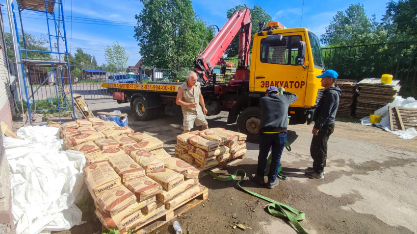 Разгрузка мешков Vetonit с краном-манипулятором на стройплощадке