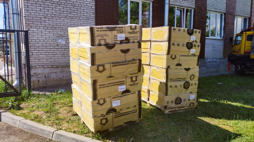 Паллеты с упаковками теплоизоляции из каменной ваты у фасада здания