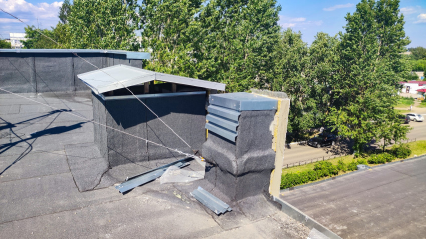 Вентиляционная шахта с металлическим козырьком на плоской кровле с рулонной гидроизоляцией