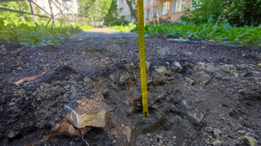 Рулетка, установленная в углубление среди щебня и камней