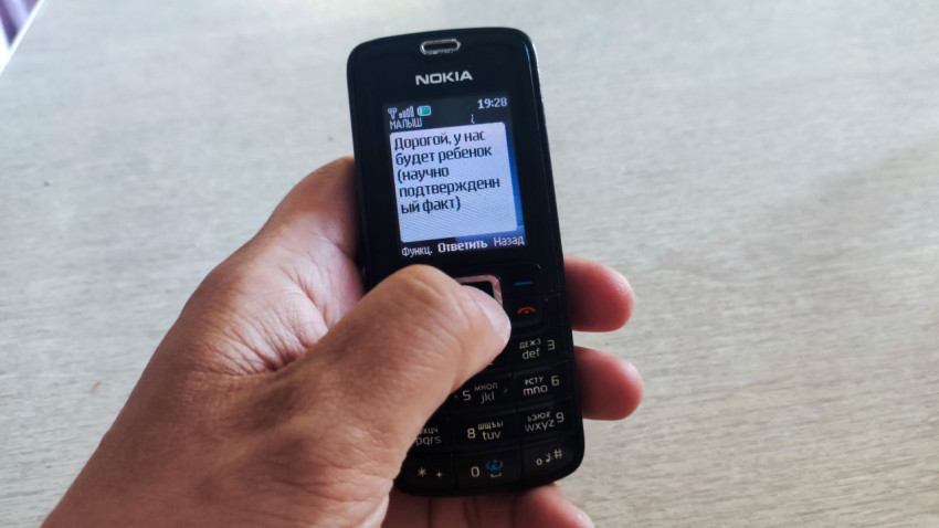 Телефон Nokia в руке на столе во время чтения SMS о беременности