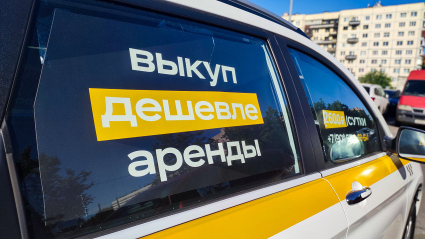 Реклама «Выкуп дешевле аренды» на боковом стекле автомобиля в бело-жёлтой оклейке