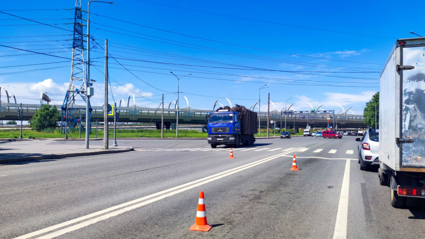 Грузовик на перекрёстке рядом с дорожными конусами у путепровода