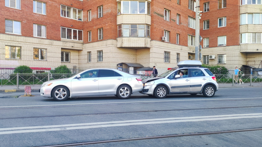 Два легковых автомобиля после столкновения на улице с трамвайными путями