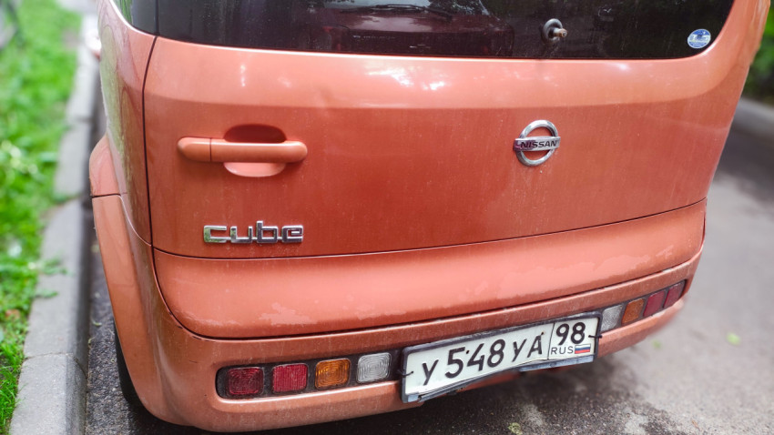 Шильдик Cube и эмблема Nissan на задней двери автомобиля крупным планом
