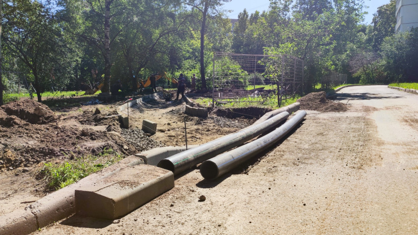 Пластиковые трубы и траншея на обочине дороги при ремонте коммуникаций