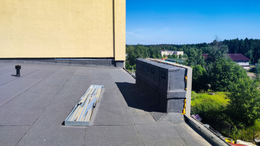 Плоская кровля с демонтированными металлическими планками и парапетом на этапе ремонта