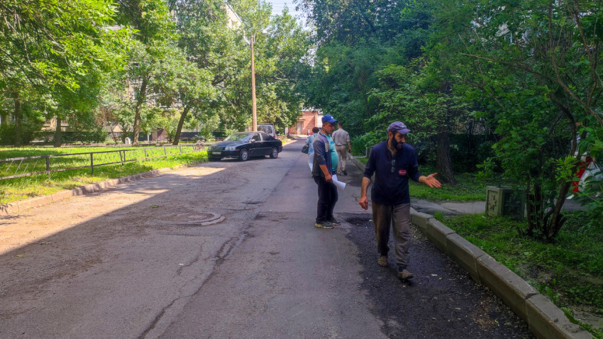 Рабочие осматривают повреждения асфальта на внутриквартальной дороге