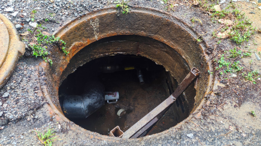 Открытый смотровой колодец с трубами и бетонными кольцами