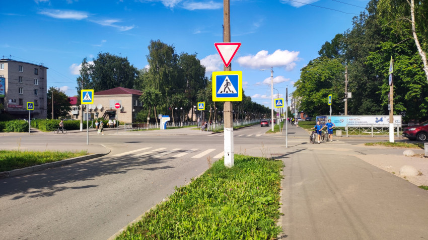 Перекрёсток с дорожными знаками и пешеходами у перехода