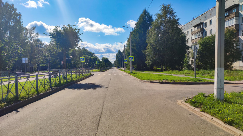 Перекрёсток городской улицы со знаками пешеходного перехода и ограждением