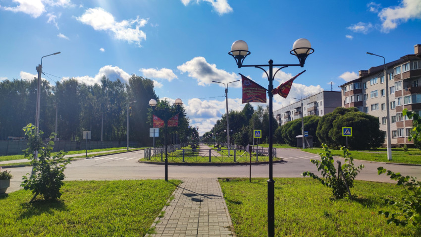 Городская улица с пешеходной зоной, ограждением и многоэтажными жилыми домами