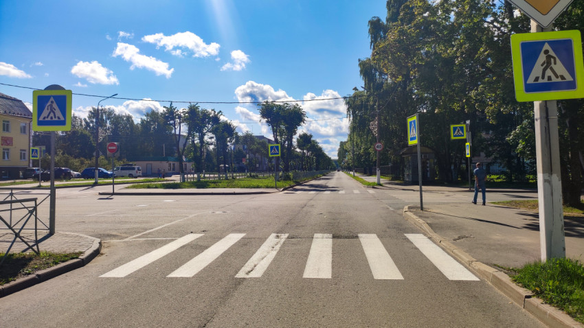 Городской перекрёсток с пешеходным переходом, дорожными знаками и остановкой