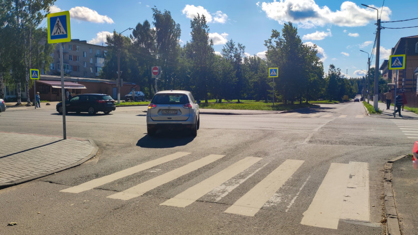 Знак «Пешеходный переход» над разметкой «зебра» на оживлённой городской улице