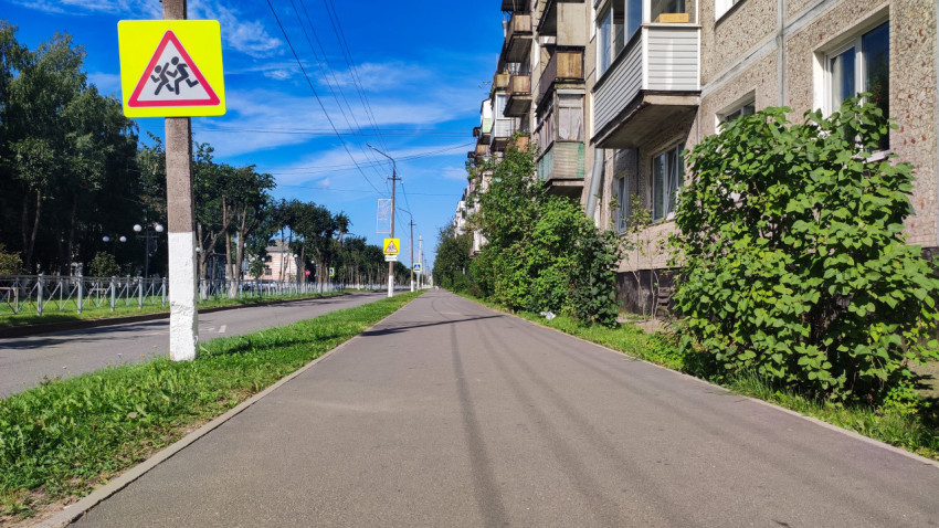 Крупный план знака «Дети» у тротуара рядом с жилым домом