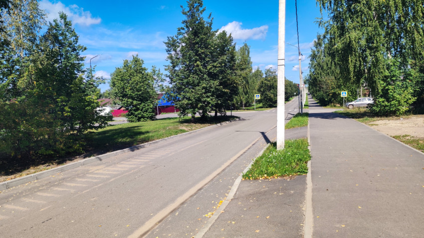 Перекрёсток в частном секторе с асфальтом, тротуаром и зелёной обочиной