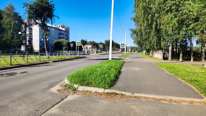 Перекрёсток с зелёным островком и знаками пешеходного перехода в жилом районе