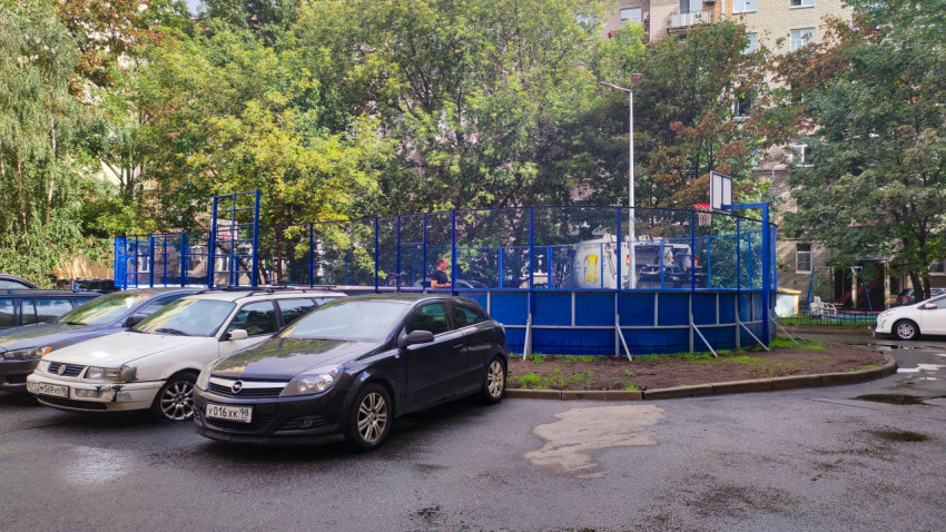 Спортивная площадка во дворе и припаркованные автомобили