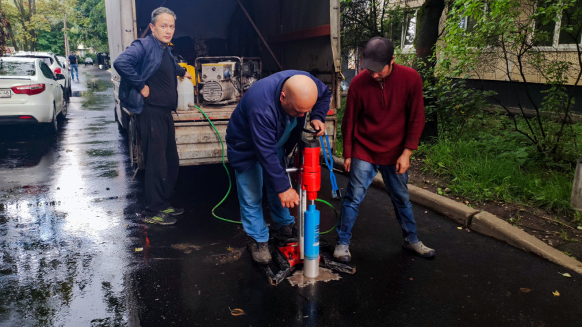 Работа буровой установки по кернению асфальта с подачей воды на городском проезде