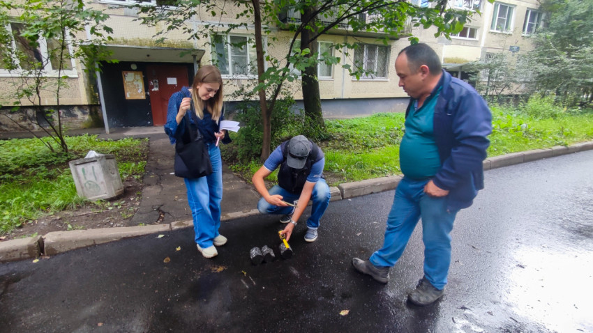 Измерение керна асфальта рулеткой и линейкой во время технического надзора на мокрой дороге