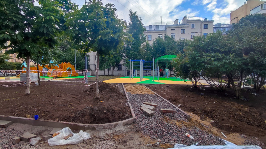 Новая детская площадка с резиновым покрытием и тренажёрами во дворе