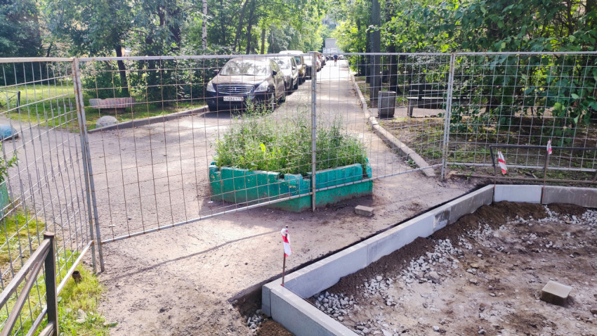 Ограждённая зона благоустройства двора с подготовкой основания и установленными бордюрами у парковки