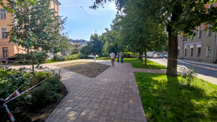 Пешеходная дорожка из тротуарной плитки и озеленение во дворе жилого квартала