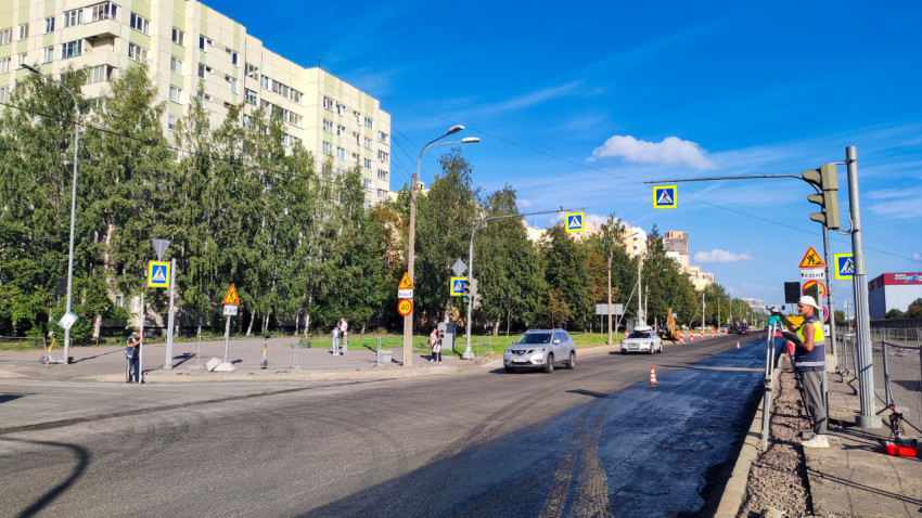 Геодезист со штативом на обочине во время ремонта городской магистрали