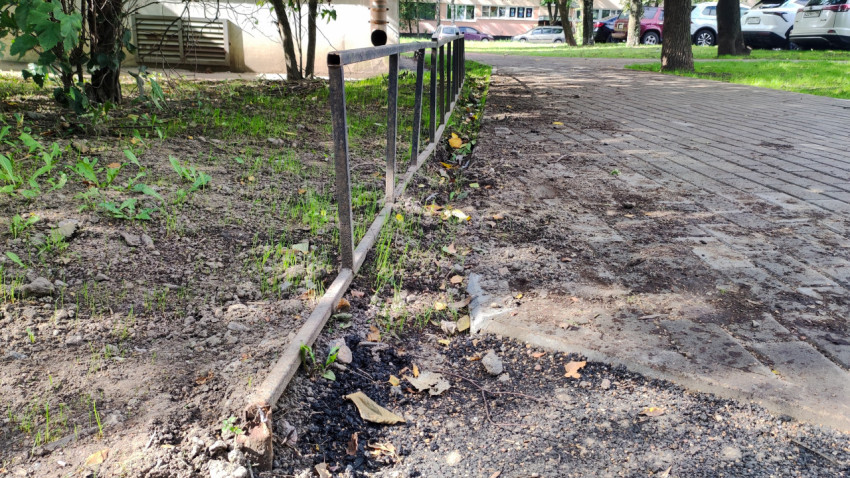 Плиточный тротуар заканчивается у асфальта, а рядом тянется заборчик и клумба с землёй