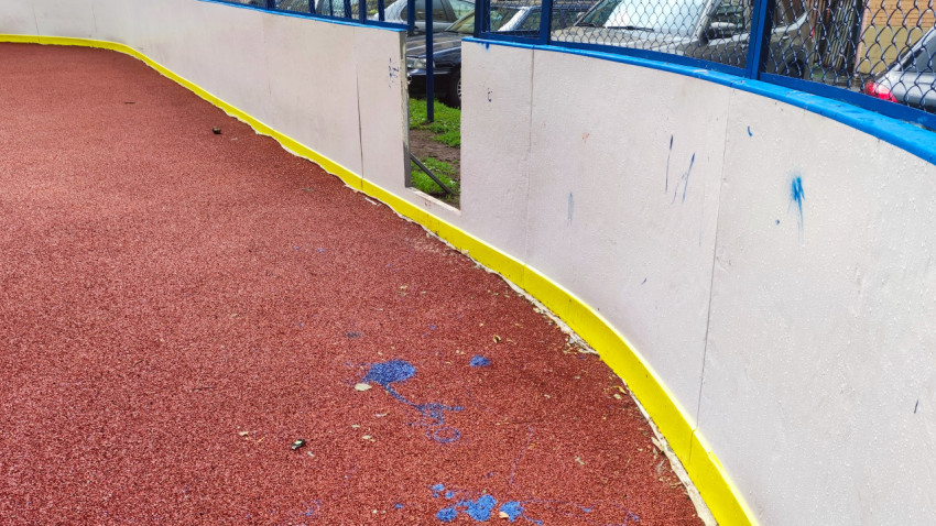 Угол спортивной коробки с изношенным резиновым покрытием