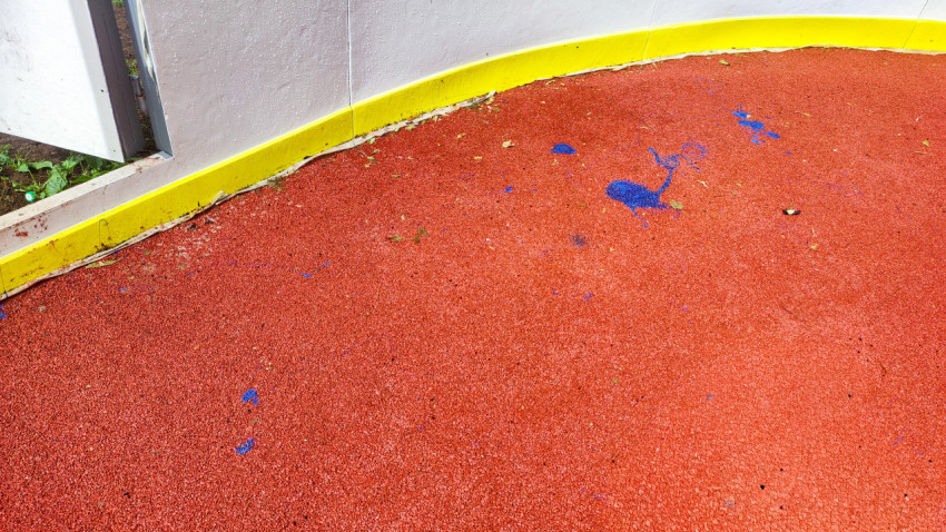 Загрязнение и следы краски в углу спортивной площадки у входа