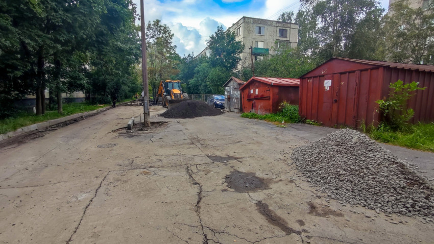 Разрушенный асфальт дворового проезда и подготовка основания к ремонту с насыпью щебня