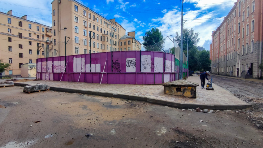 Дорожные работы у ограждения спортивной площадки с виброплитой