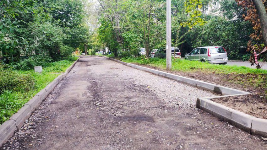 Дворовой проезд с бордюрами и полосой щебёночного основания вдоль кромки дороги