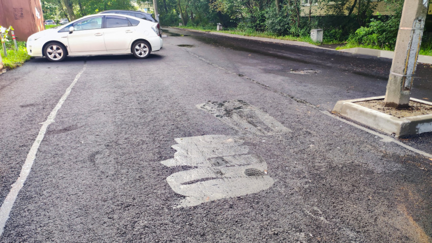 Заплатка асфальта вокруг люка и парковочной разметки на дворовой дороге