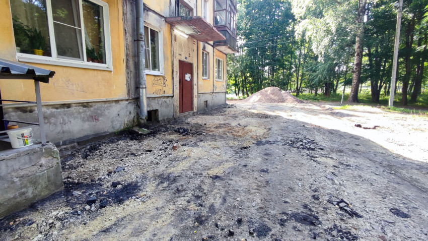 Разобранный участок асфальта и щебёночная подсыпка на ремонте дворового проезда