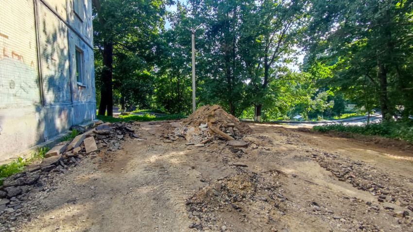 Куча разобранного асфальта и грунта на дворовой территории во время дорожных работ