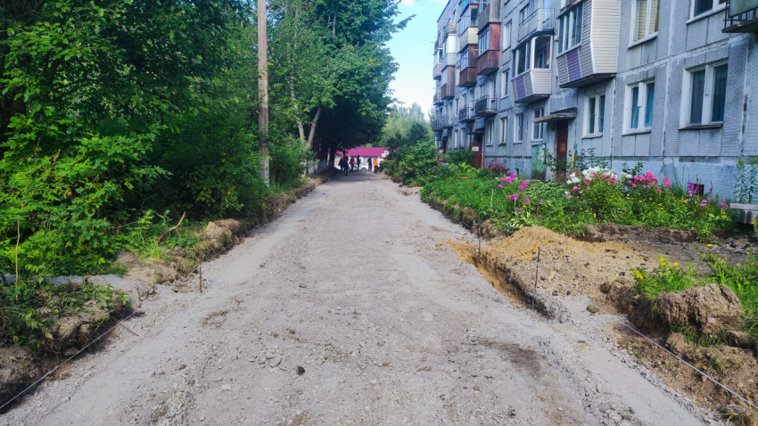 Подготовка основания дворовой дороги с разметкой шнурами у многоквартирного дома и цветников