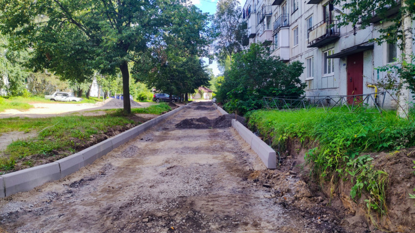 Подготовка дворового проезда между бордюрами с песчано-щебёночным основанием рядом с жилым домом