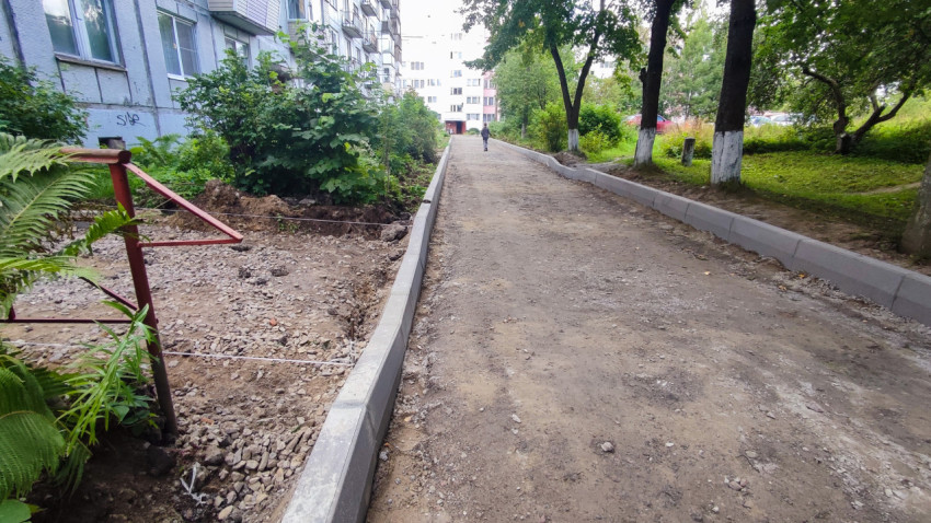 Дворовый проезд на стадии благоустройства с новыми бордюрами и щебёночным основанием