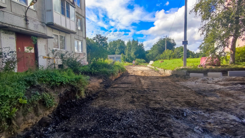 Грейдирование грунтовой дороги у дома с выемкой земли и уложенным слоем крошки